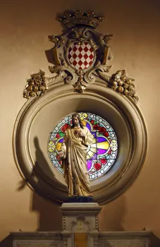 Saint Devota Church, Jesus statue in front of a circular window with ornaments and coat of arms